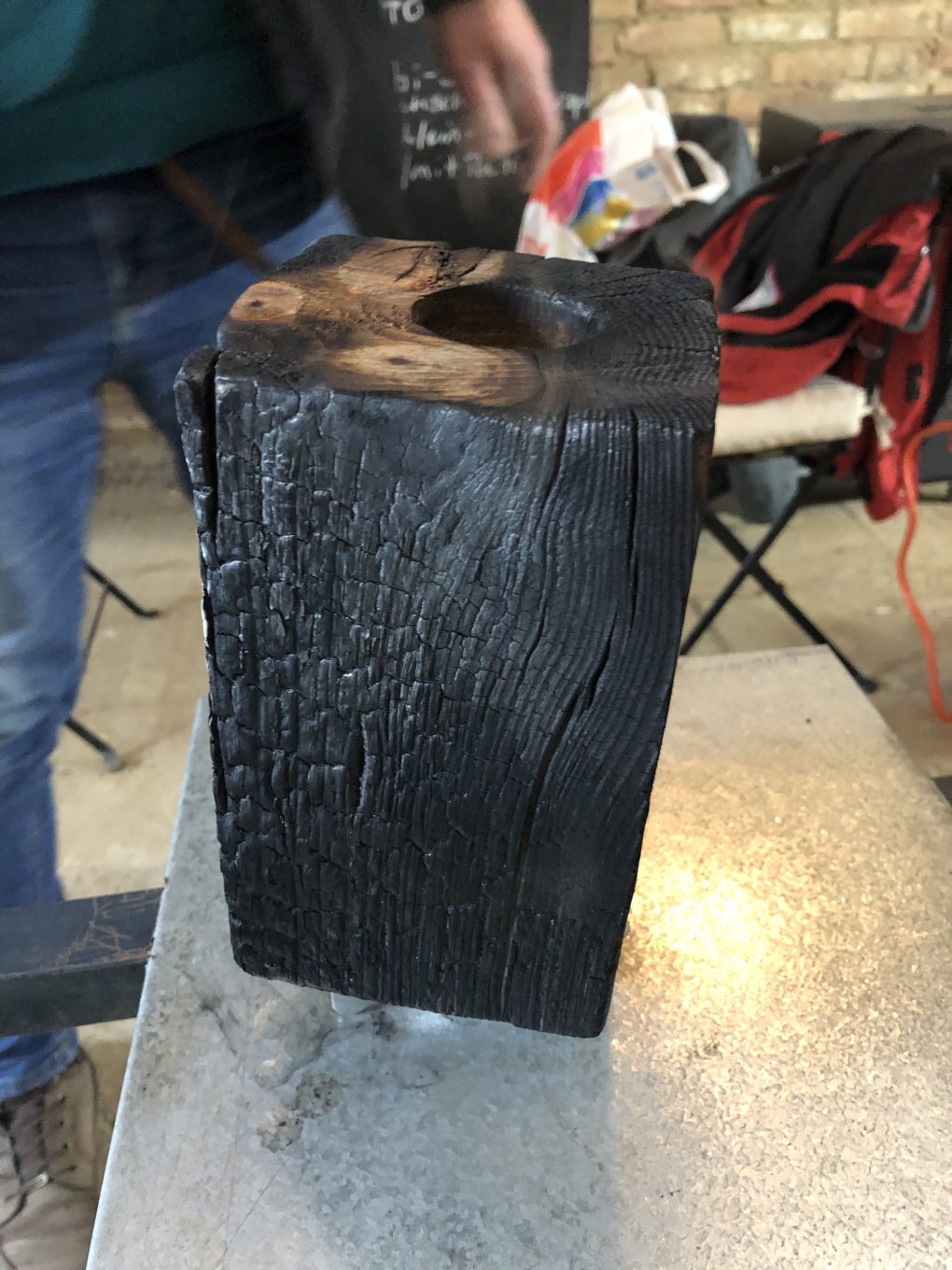 Ein Holzstück wird in der Shou Sugi Ban-Technik bearbeitet